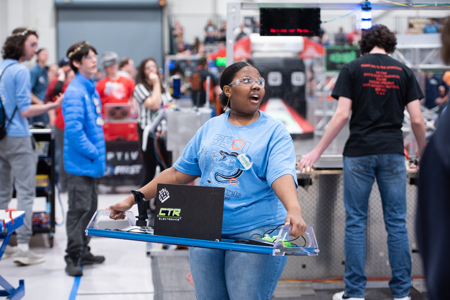 Smiling young woman holding robotic controls
